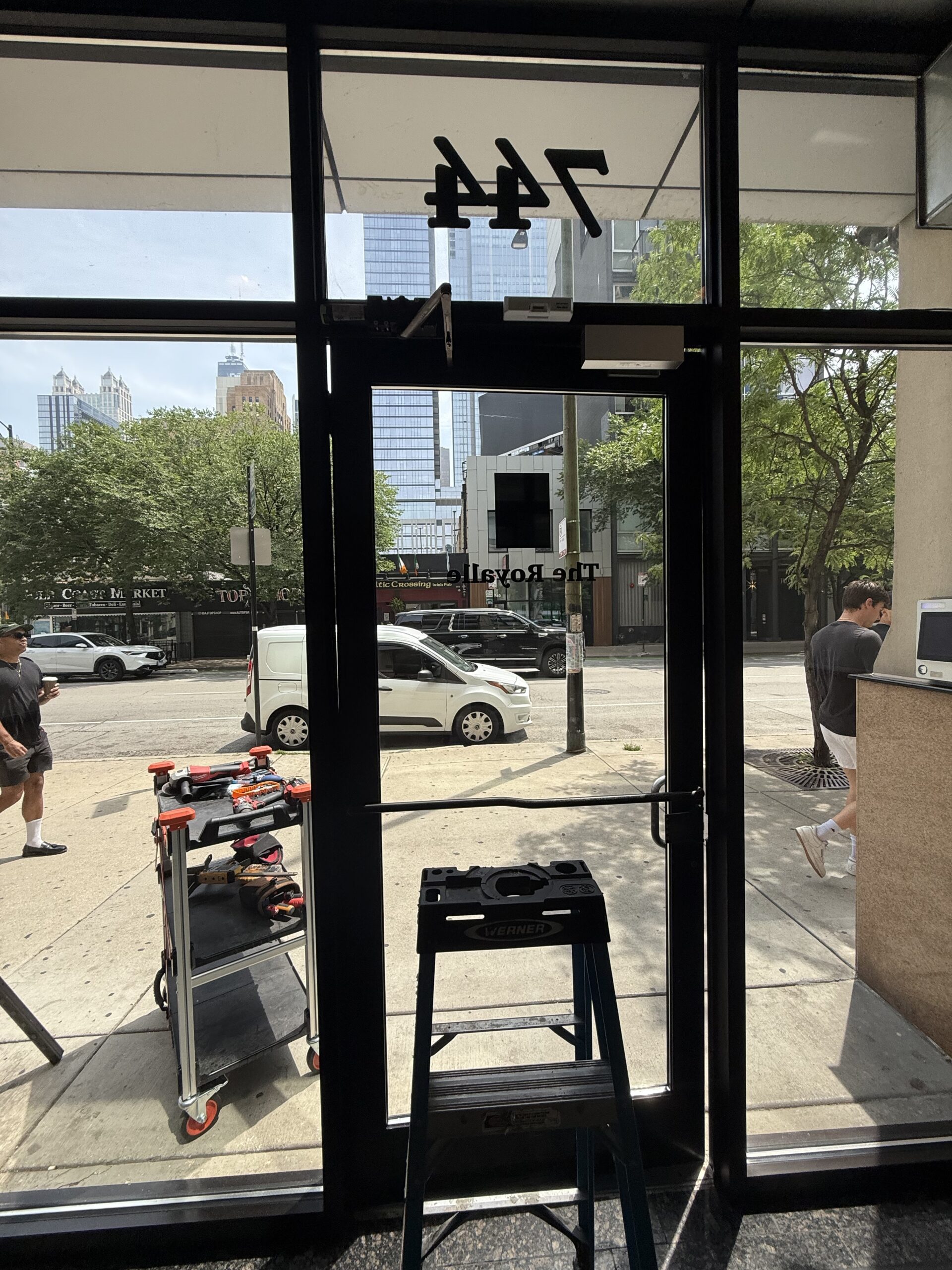 Commercial locksmith repairing Roton continuous hinge on aluminum storefront door in Pilsen Chicago