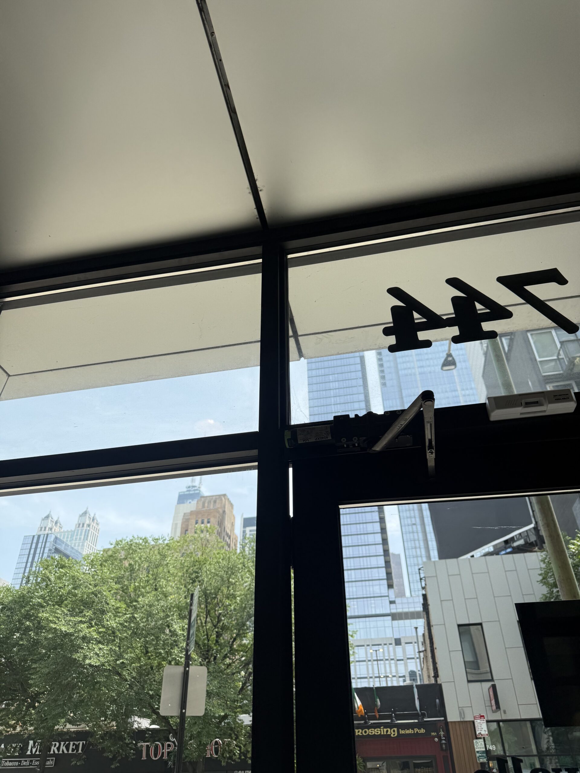 Commercial locksmith hanging aluminum storefront door with continuous hinge in Pilsen Chicago