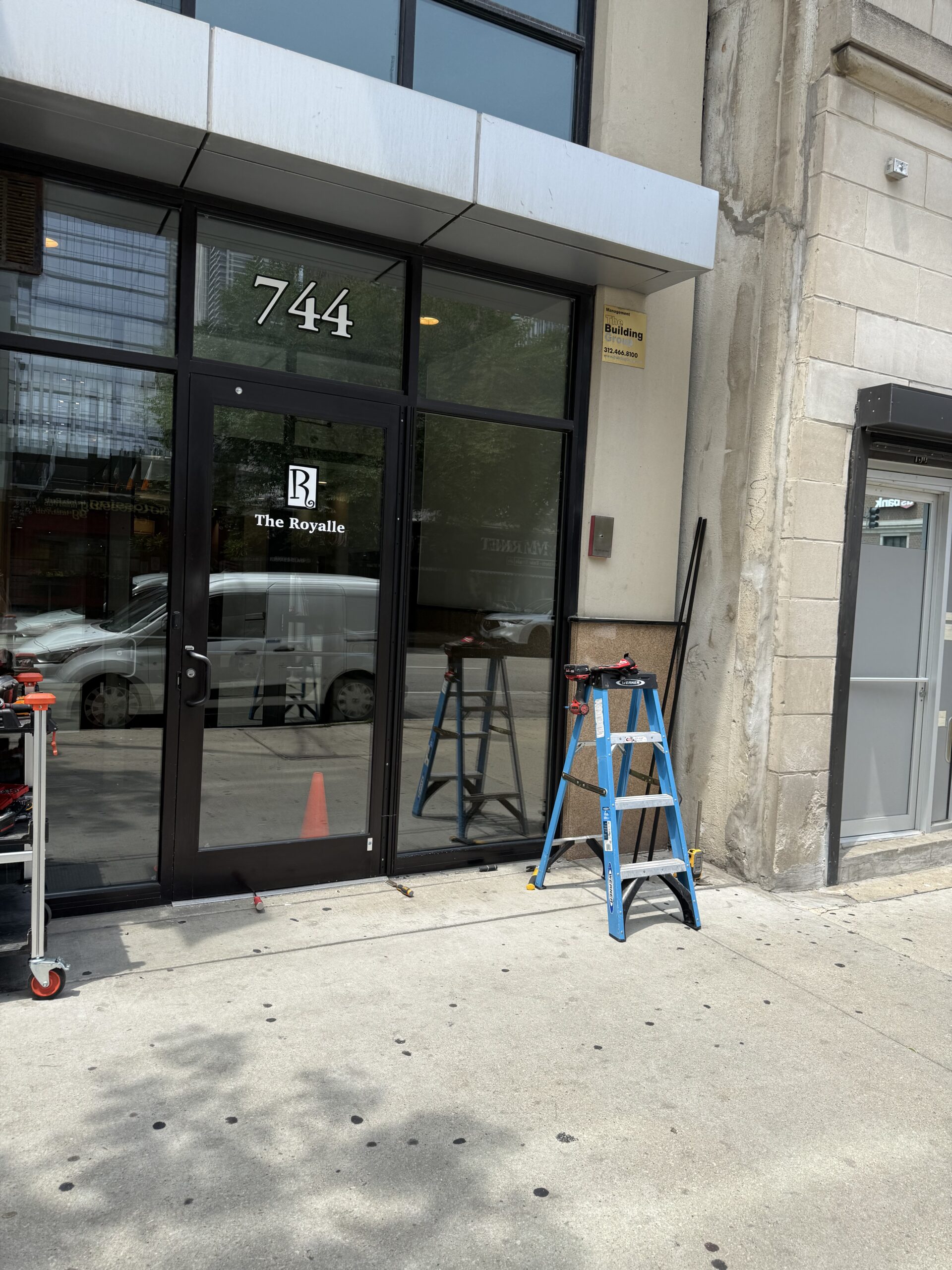 Commercial locksmith installing continuous hinge on aluminum door in Pilsen Chicago